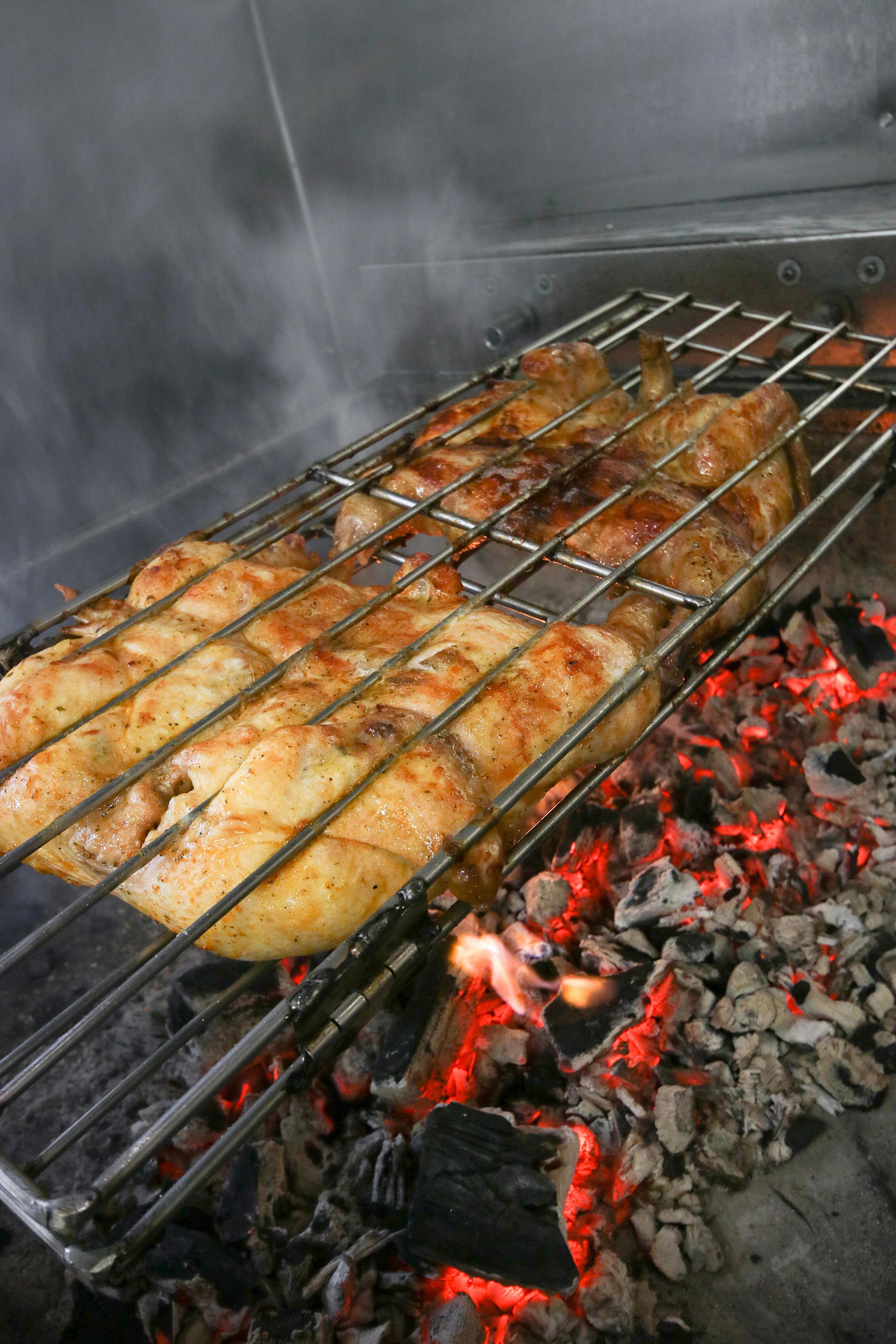 plusieurs morceaux de poulet qui cuisse au charbon